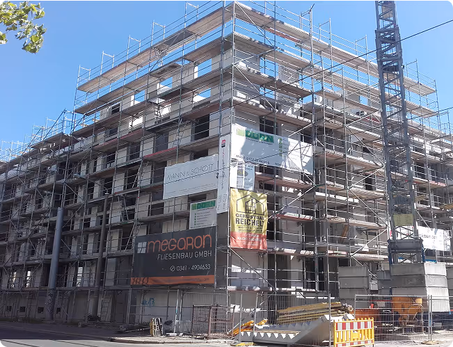 Mehrgeschossiger Neubau mit Gerüst und Bannern von Trockenbau Dorn