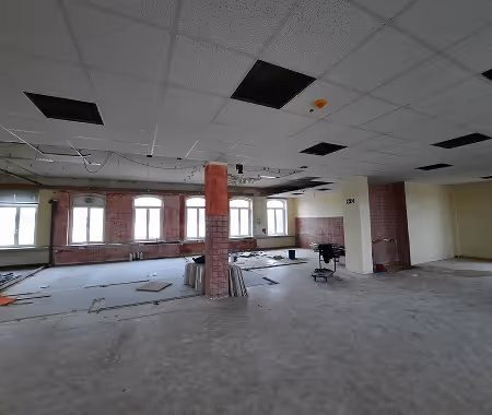 Sanierung einer Gewerbehalle mit Backsteinwänden und abgehängter Rasterdecke